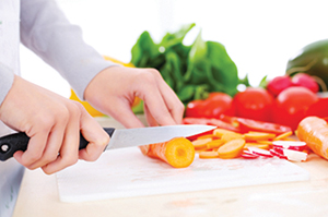 Woman's hands cutting vegetables.